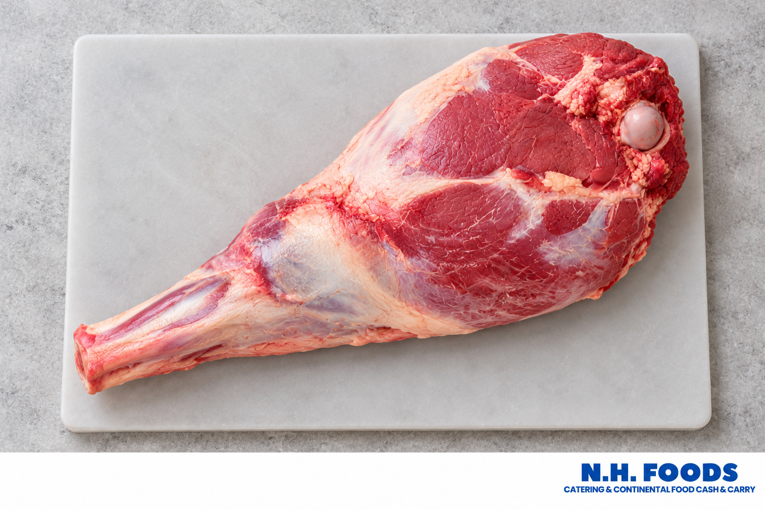 Fresh raw bone-in lamb leg on a light butcher board